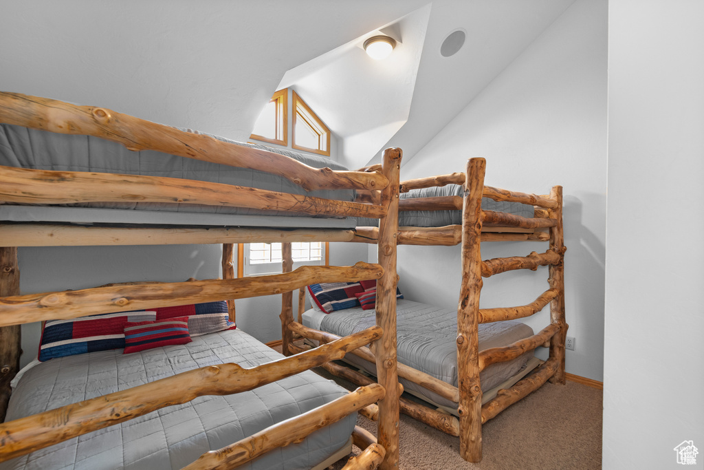 Bedroom featuring vaulted ceiling, carpet, and baseboards
