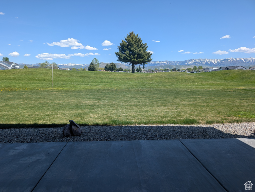 View of green lawn featuring a mountain view