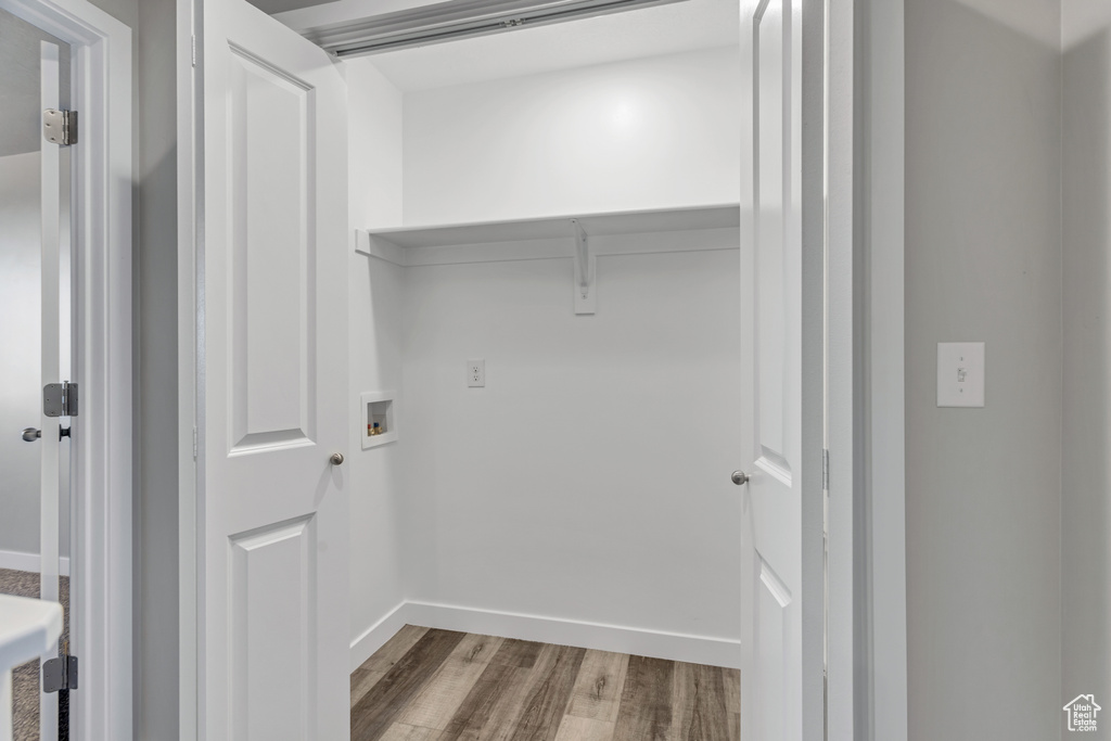 Clothes washing area with washer hookup, laundry area, wood finished floors, and baseboards
