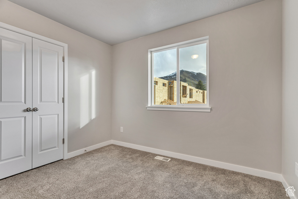 Unfurnished bedroom with a closet, visible vents, baseboards, and carpet