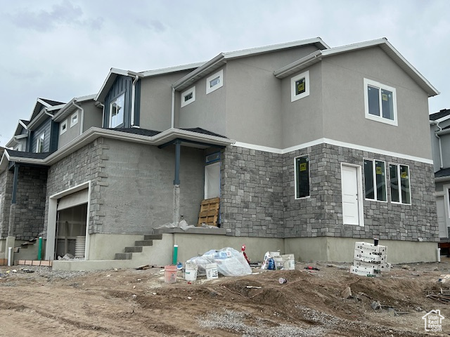 View of front of property with stone siding and stucco siding