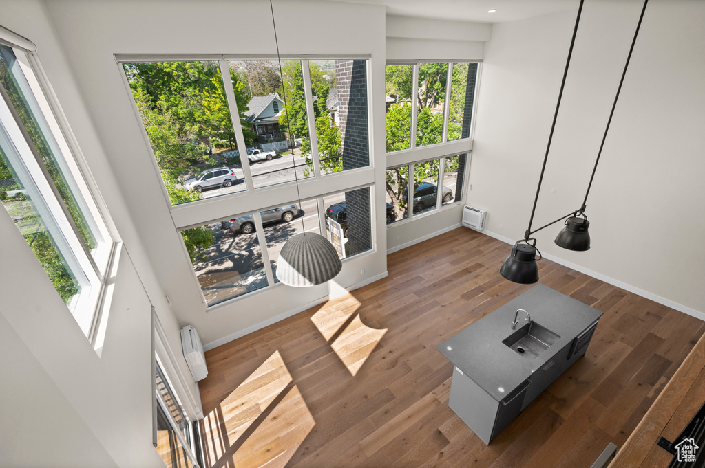Living area featuring a wall mounted air conditioner, baseboards, and wood finished floors
