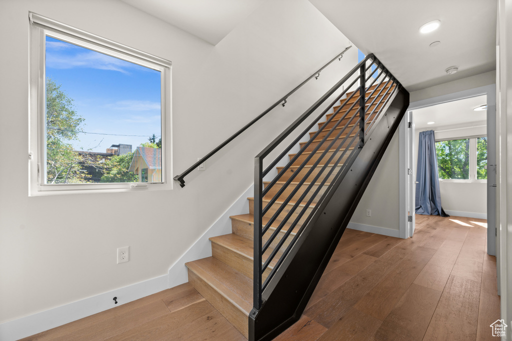 Staircase with hardwood / wood-style floors, baseboards, and recessed lighting