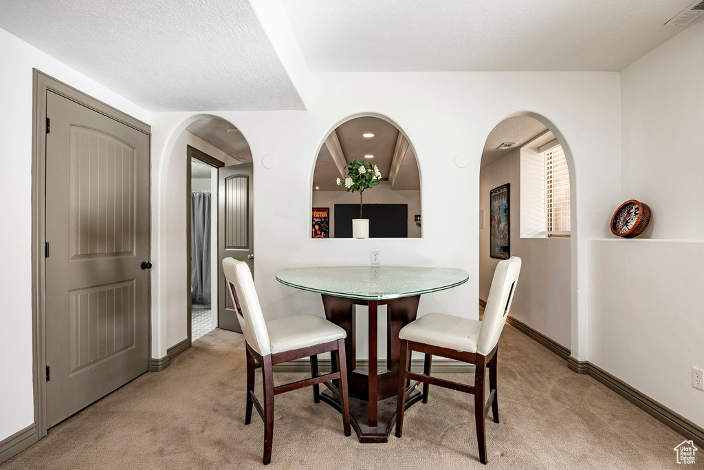 Dining room with carpet, baseboards, and arched walkways