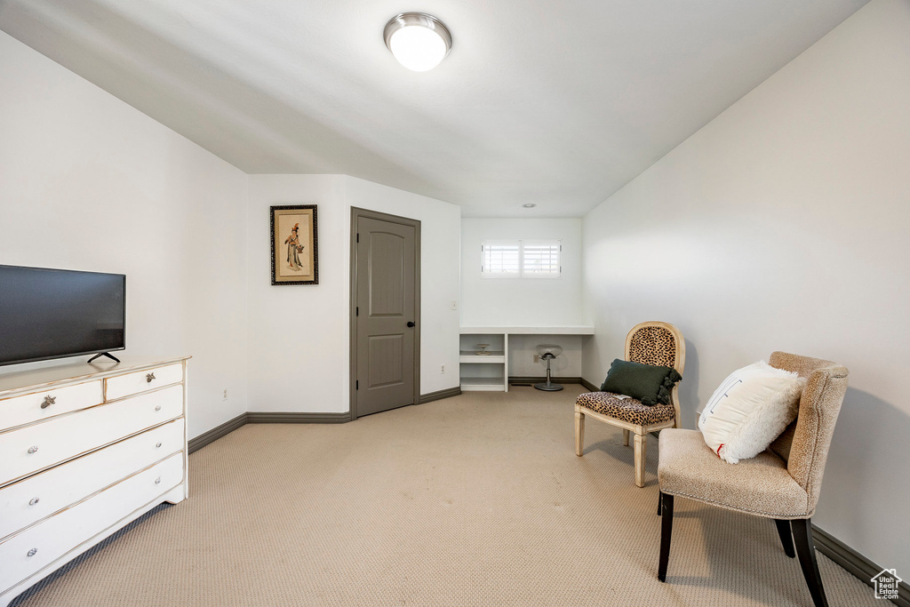Living area featuring light colored carpet, baseboards, and an office area