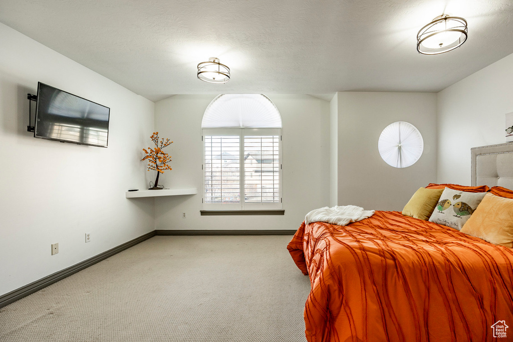Bedroom featuring carpet and baseboards