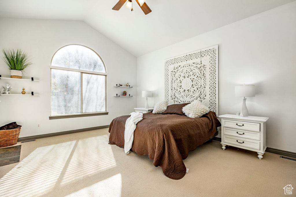 Bedroom featuring lofted ceiling, light carpet, ceiling fan, and baseboards