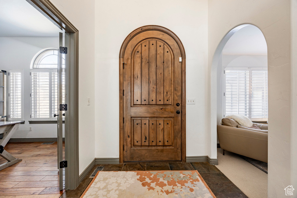 Foyer featuring arched walkways and baseboards