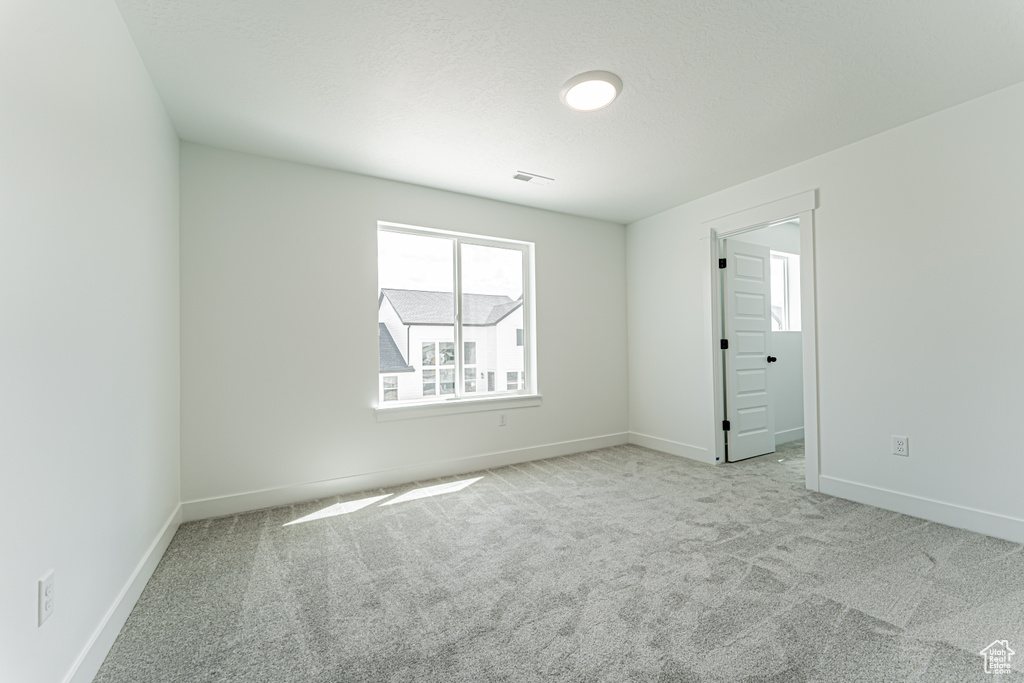 Empty room with carpet flooring and plenty of natural light
