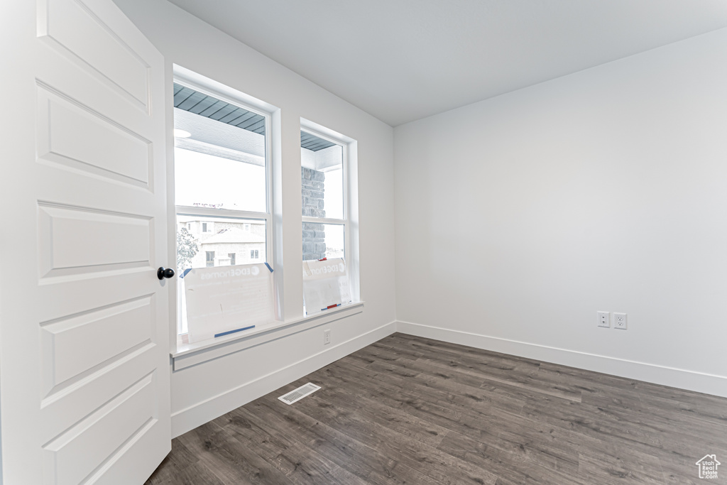 Unfurnished room with dark wood-type flooring