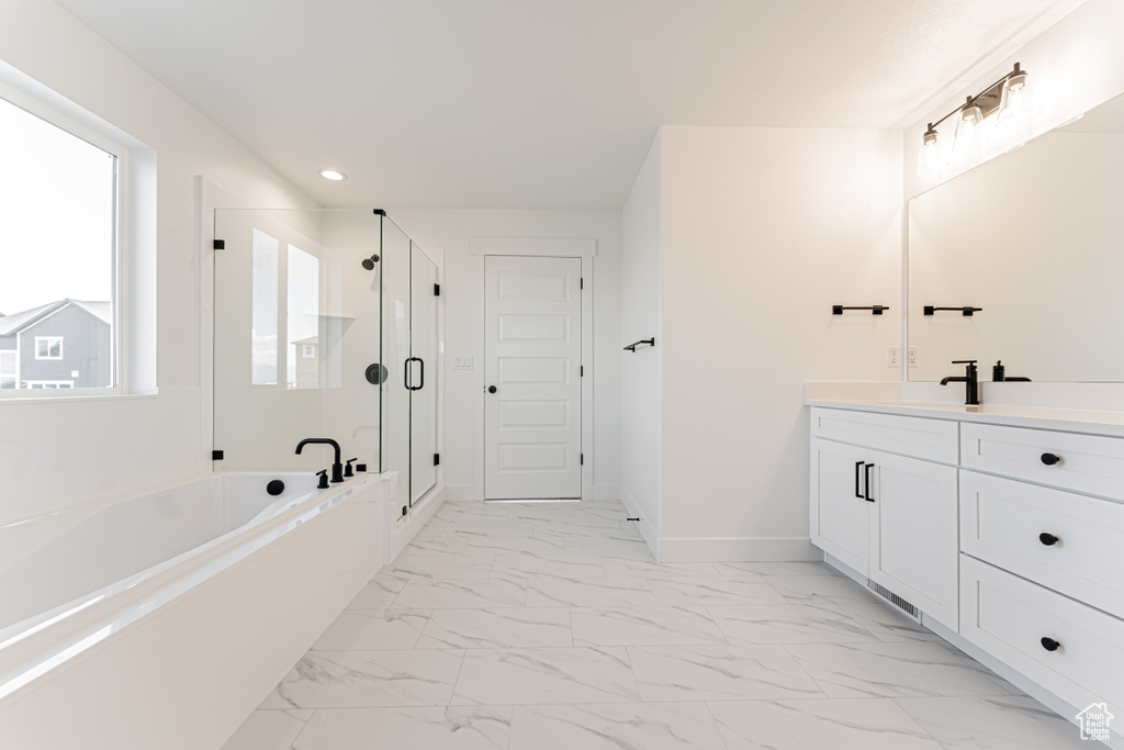 Full bathroom with vanity, a bath, a shower stall, recessed lighting, and marble look tile flooring
