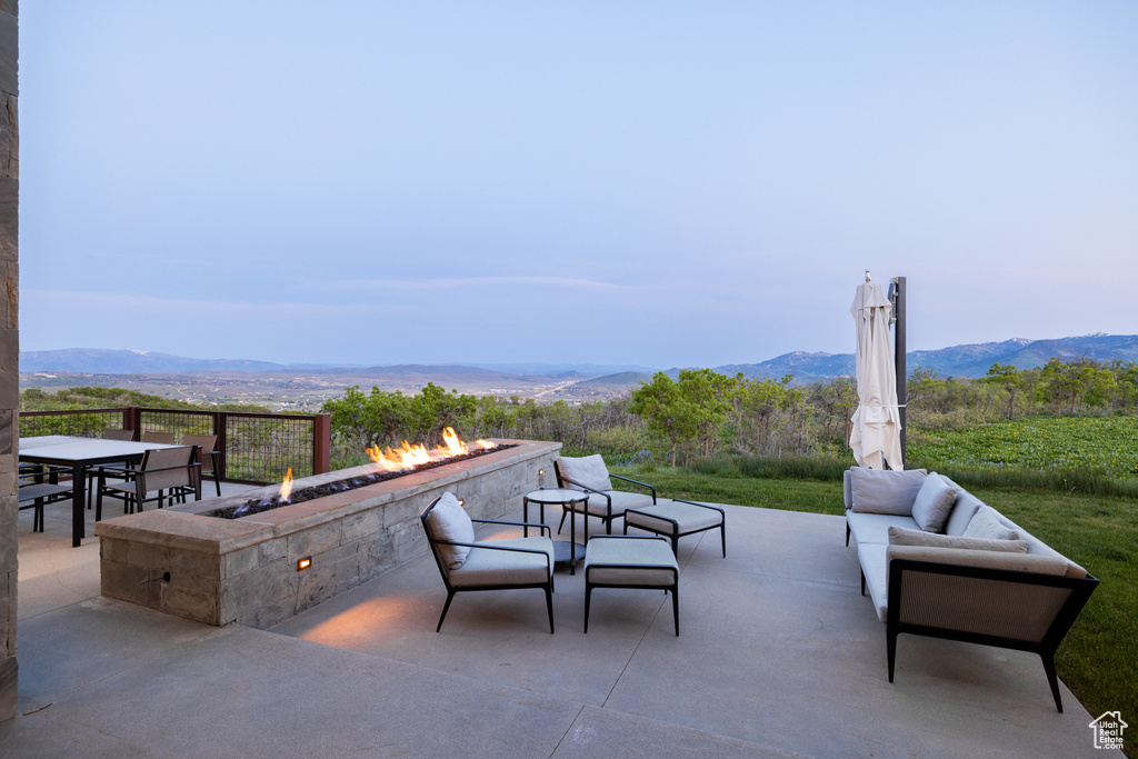 View of patio / terrace featuring an outdoor living space with a fire pit and a mountain view