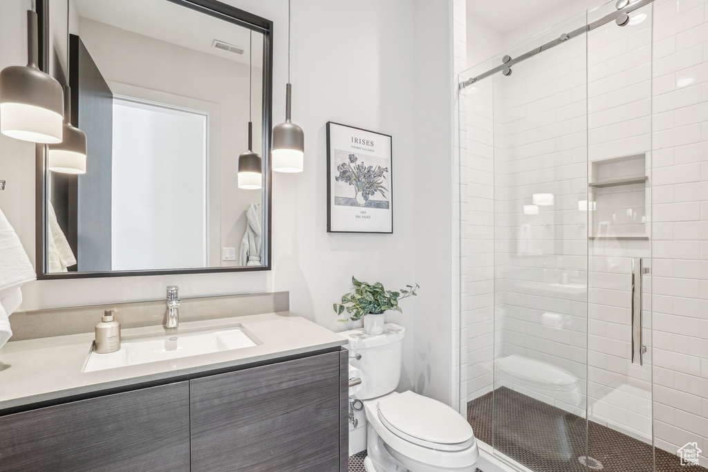 Full bath featuring toilet, vanity, and a shower stall