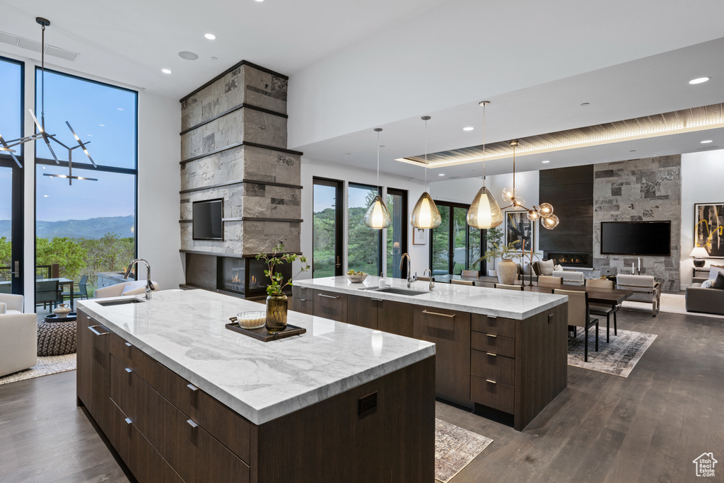 Kitchen featuring a large island, modern cabinets, a chandelier, a sink, and expansive windows