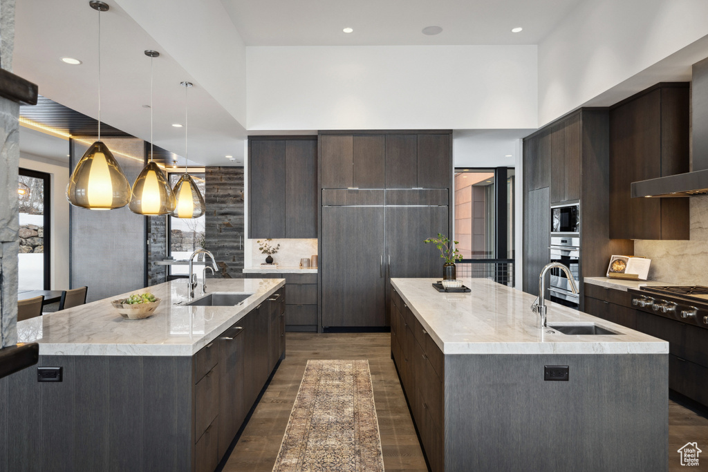 Kitchen featuring a spacious island, a sink, modern cabinets, stainless steel oven, and recessed lighting