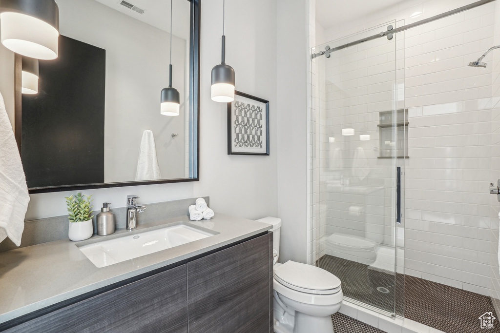 Full bathroom with toilet, a shower stall, and vanity