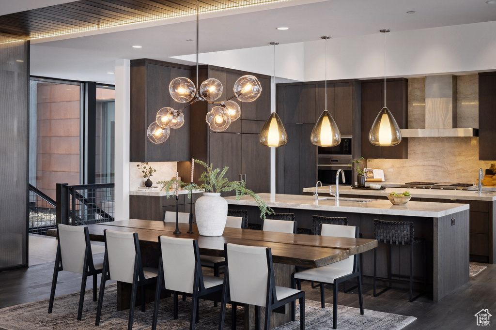 Dining space with dark wood-style flooring, a chandelier, stairway, and recessed lighting