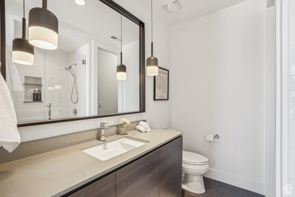 Full bathroom with vanity, toilet, tile patterned flooring, and tiled shower
