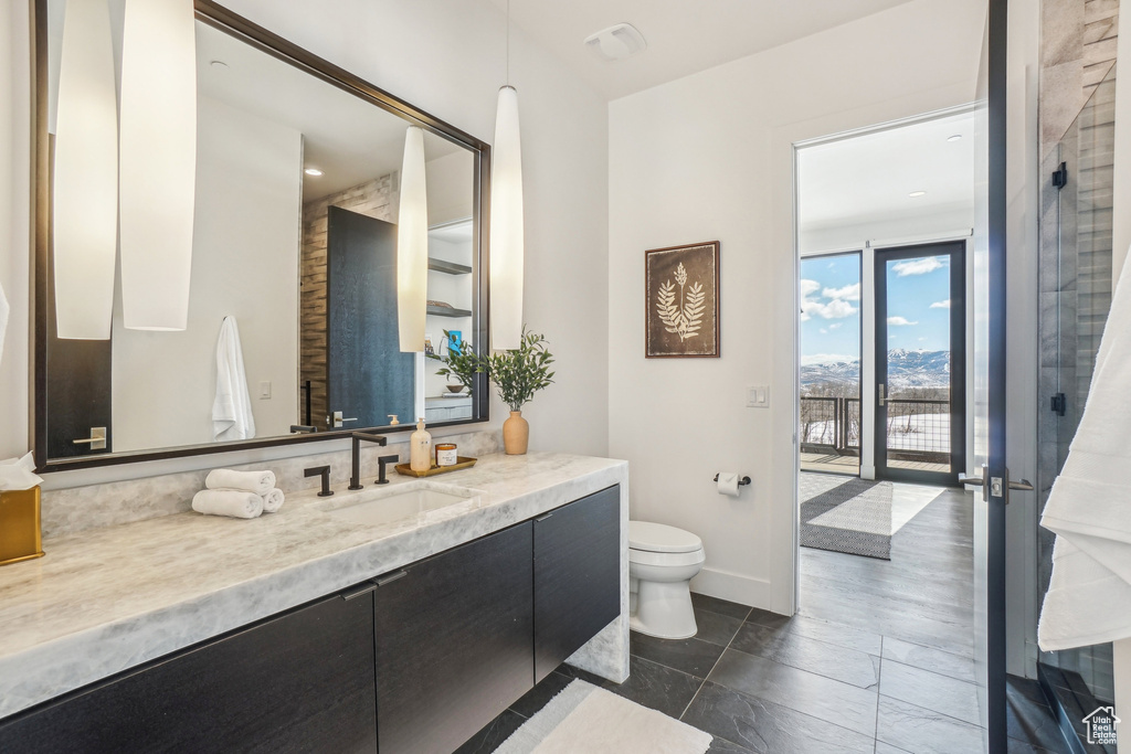 Bathroom with vanity, toilet, and baseboards