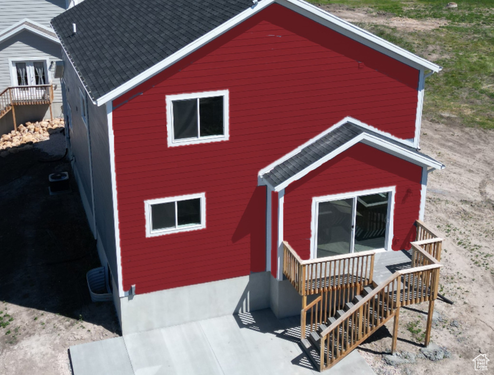 Exterior space featuring cooling unit, roof with shingles, and a deck