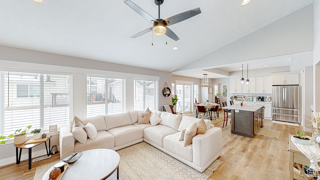 Living area featuring a ceiling fan, baseboards, lofted ceiling, recessed lighting, and light wood-type flooring