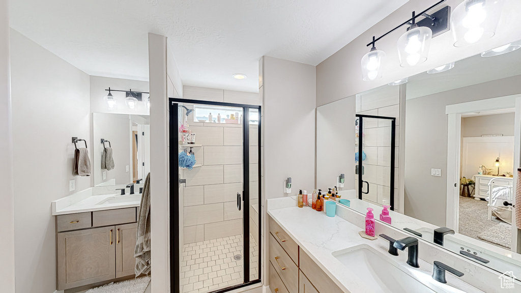 Full bathroom with a stall shower, two vanities, and a sink