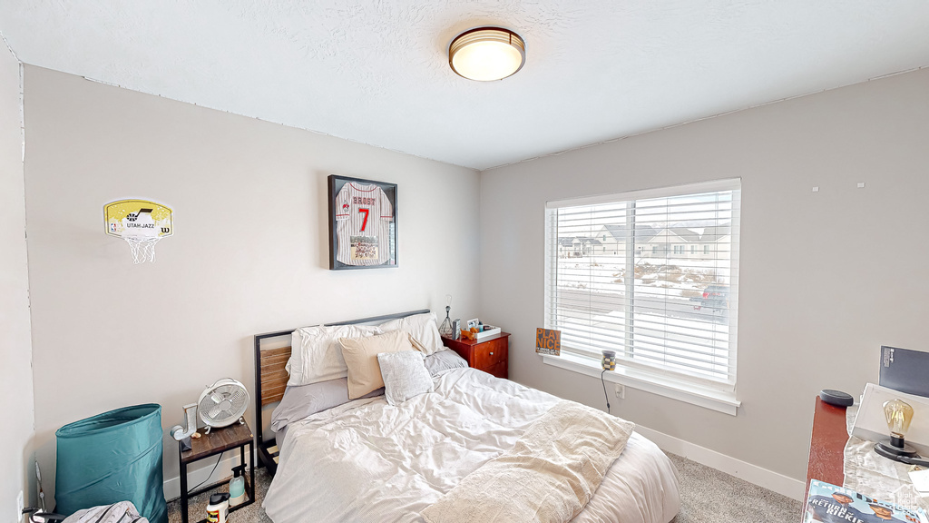 Bedroom featuring a textured ceiling, baseboards, and carpet floors