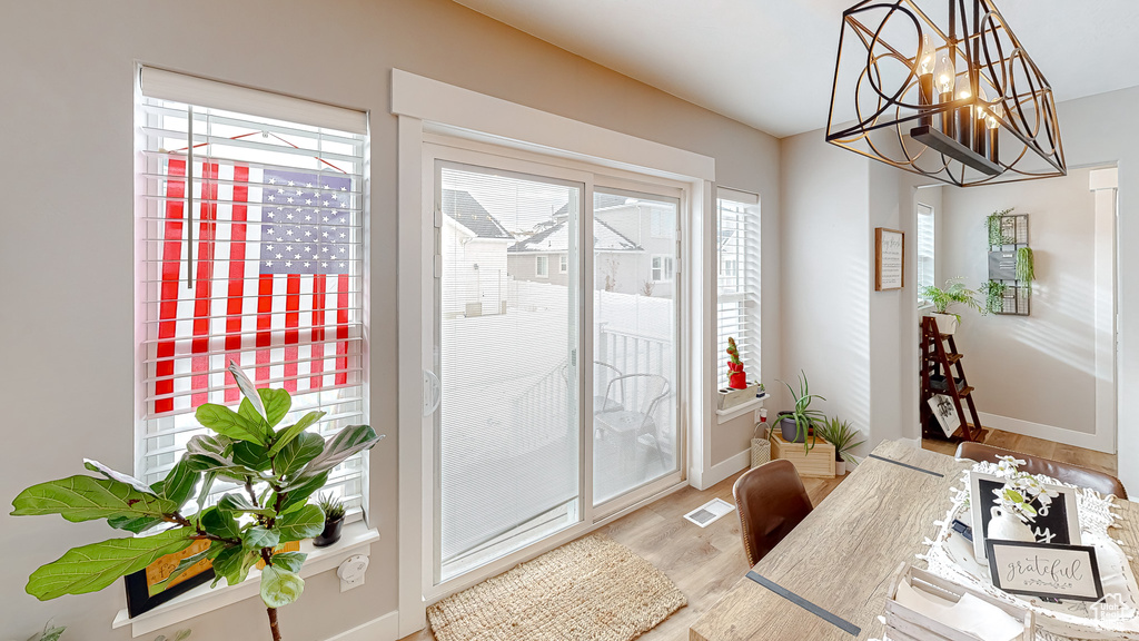 Interior space with visible vents, wood finished floors, baseboards, and a chandelier