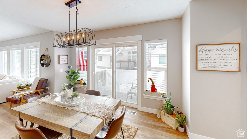 Dining area featuring visible vents, plenty of natural light, a chandelier, and light wood finished floors