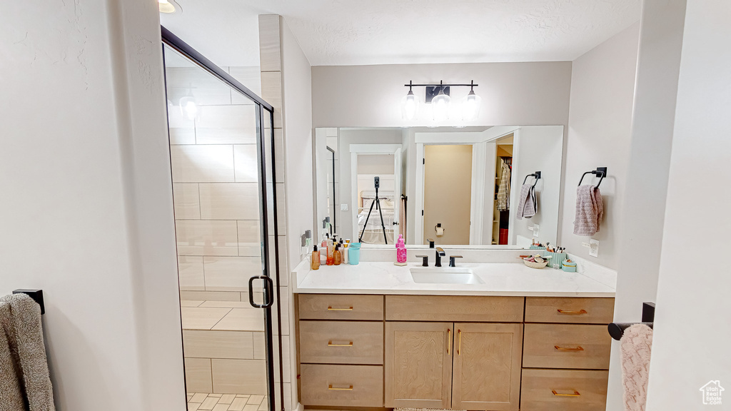 Full bath featuring a stall shower and vanity