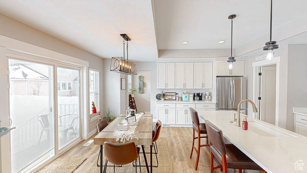 Dining space with an inviting chandelier, recessed lighting, and light wood-type flooring