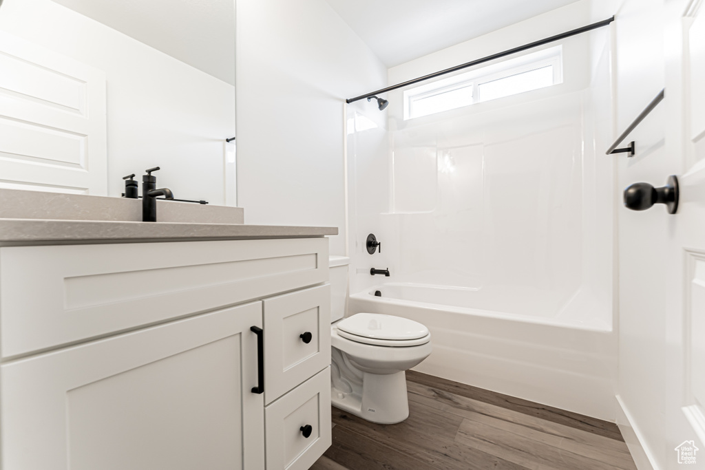 Bathroom featuring vanity, wood finished floors, and shower / tub combination