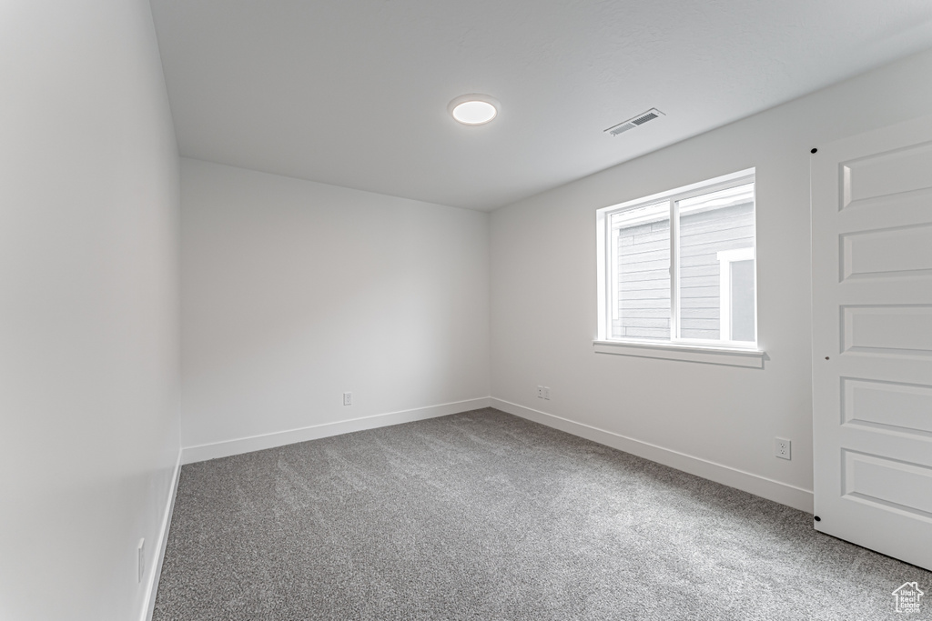 Carpeted empty room featuring baseboards