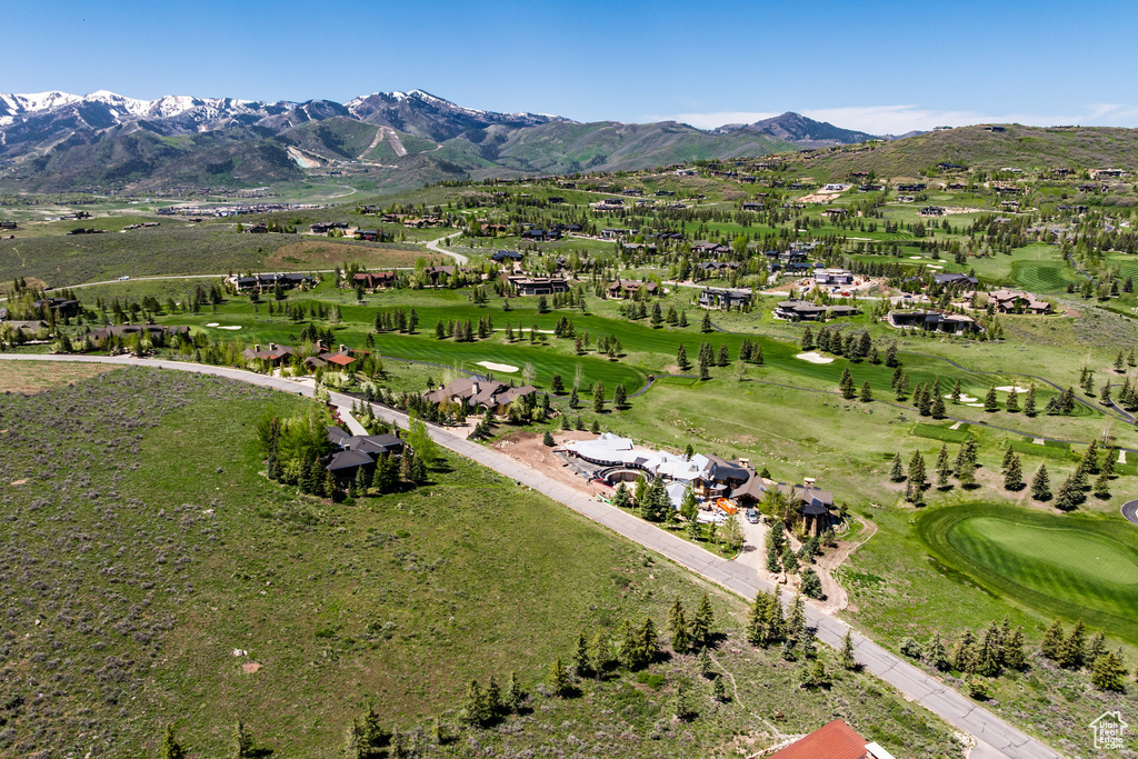 Aerial view of property and surrounding area with mountains and a local golf course