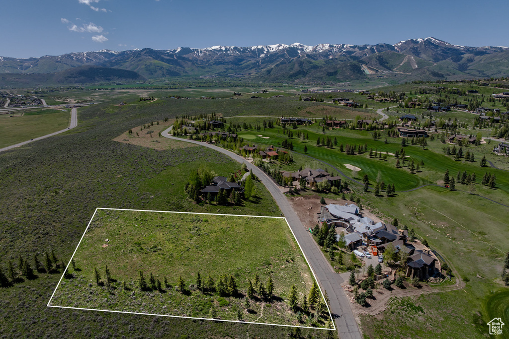 Aerial view of property and surrounding area featuring a mountain backdrop and property parcel outlined