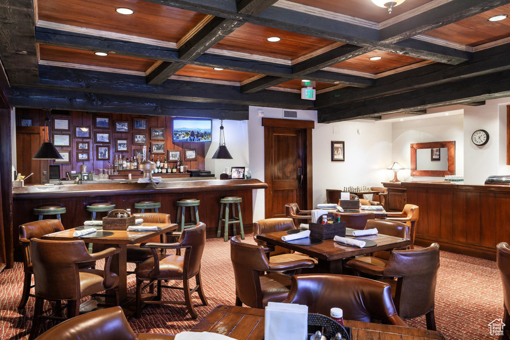Dining area featuring carpet, beamed ceiling, a community bar, coffered ceiling, and recessed lighting