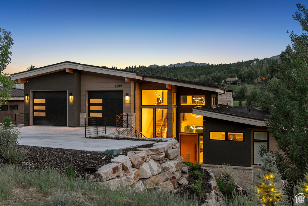 View of front of property with an attached garage, driveway, and a mountain view