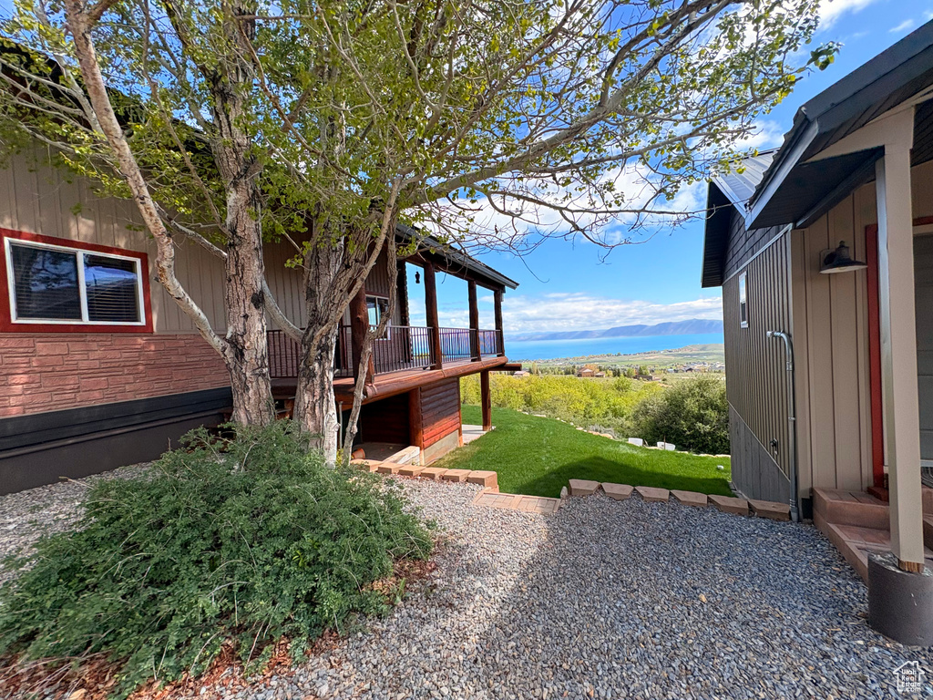 View of side of property with a wooden deck and a patio