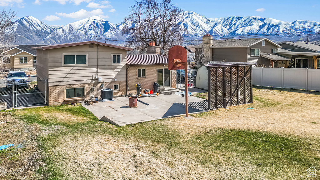 Back of property with a standing seam roof, an outdoor structure, a storage shed, a mountain view, and metal roof