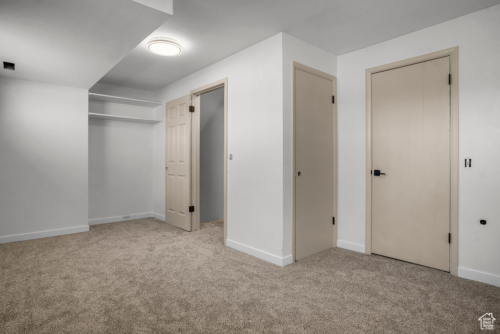 Unfurnished bedroom featuring a closet, baseboards, and carpet