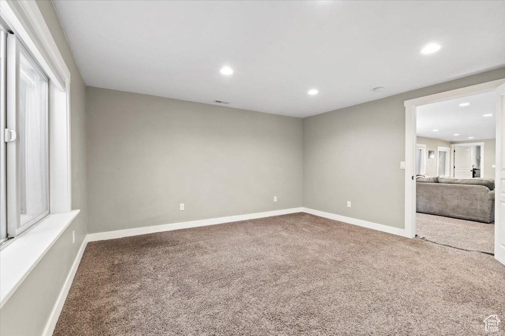 Carpeted empty room with visible vents, recessed lighting, and baseboards