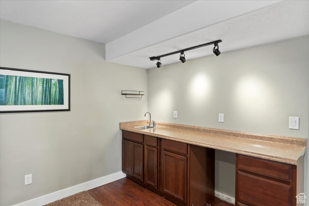 Kitchen featuring dark wood finished floors, light countertops, baseboards, and a sink