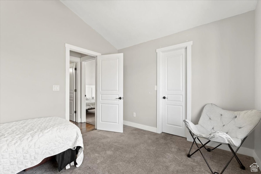 Bedroom featuring baseboards, carpet, and vaulted ceiling