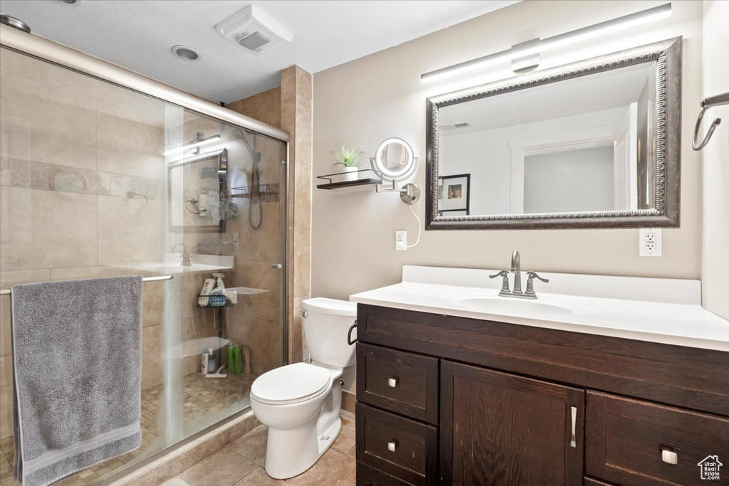 Bathroom with tile patterned flooring, visible vents, toilet, a stall shower, and vanity