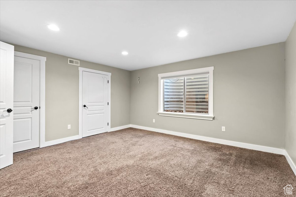 Unfurnished bedroom with recessed lighting, carpet flooring, baseboards, and visible vents