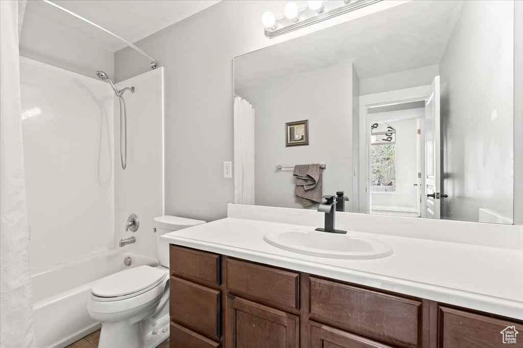 Bathroom with shower / bath combo with shower curtain, toilet, and vanity