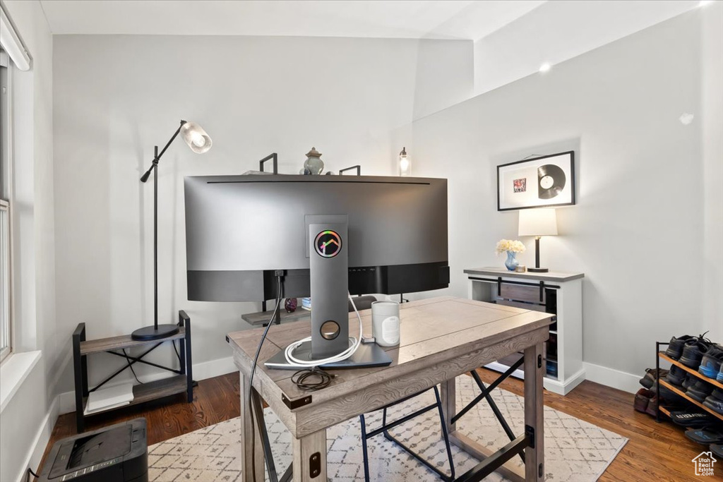 Office area with baseboards, lofted ceiling, and wood finished floors