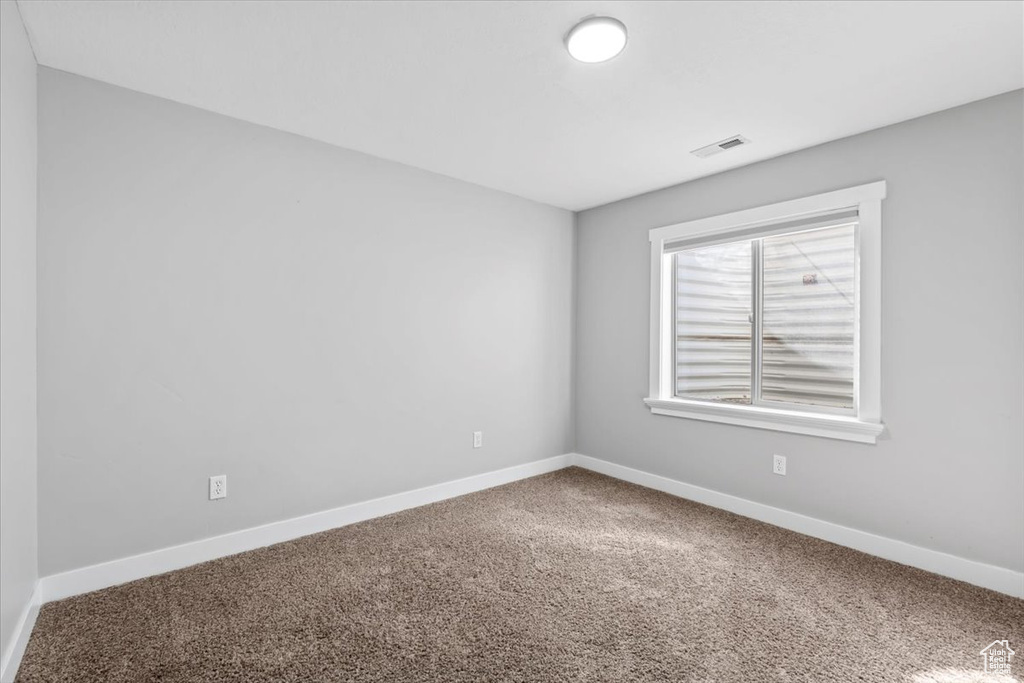 Carpeted spare room with baseboards and visible vents