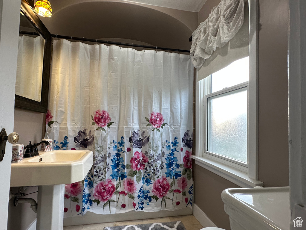 Full bathroom featuring curtained shower and baseboards