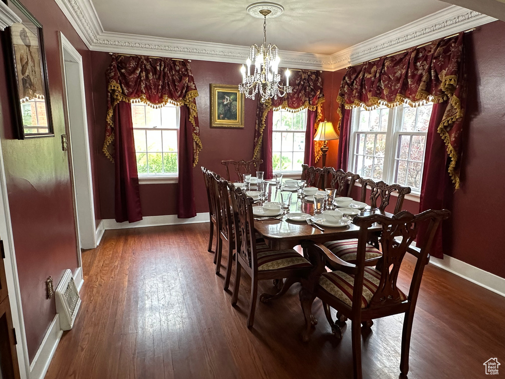 Dining space featuring a wealth of natural light, baseboards, wood finished floors, and ornamental molding